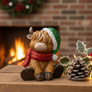 FIGURINE DE VACHE HIGHLAND ASSISE EN POLYRÉSINE POUR LES FÊTES